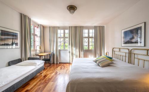 um quarto de hotel com duas camas e uma secretária em Hotel Hofgarten Luzern em Lucerna