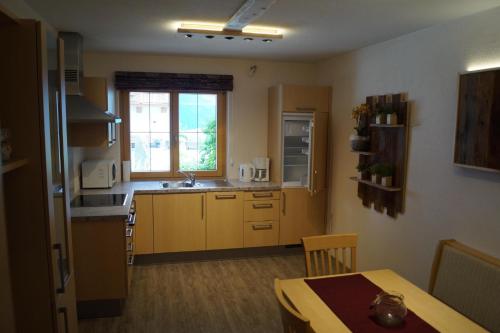 une cuisine avec une table et un évier ainsi qu'une fenêtre. dans l'établissement Appartment Martina, à Fügenberg