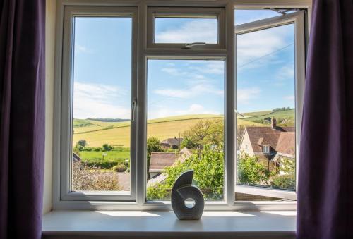 a window with a view of the rolling hills at Avocet House in West Lulworth