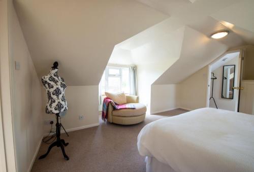 a white room with a bed and a chair at Avocet House in West Lulworth