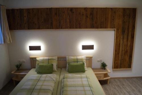 1 dormitorio con 2 camas y almohadas verdes en Appartment Martina, en Fügenberg