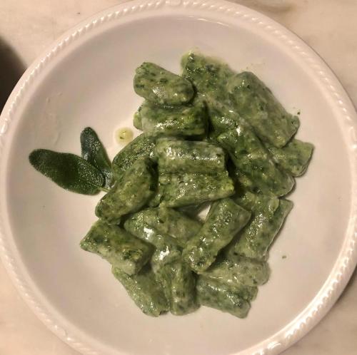 a plate of green pasta on a white plate at Corte Pioppazza in Ceresara