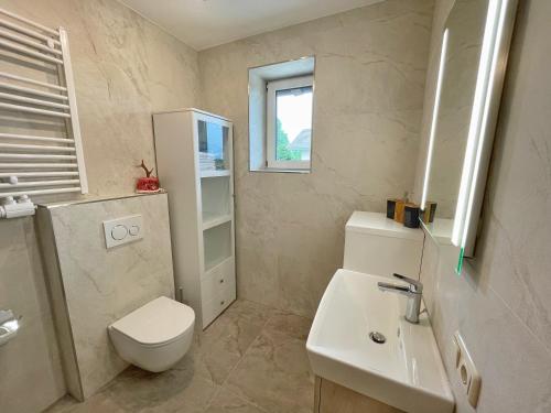 La salle de bains est pourvue de toilettes et d'un lavabo. dans l'établissement Pension Erlhof, à Saalfelden