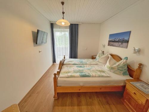a bedroom with a bed and a large window at Pension Erlhof in Saalfelden am Steinernen Meer