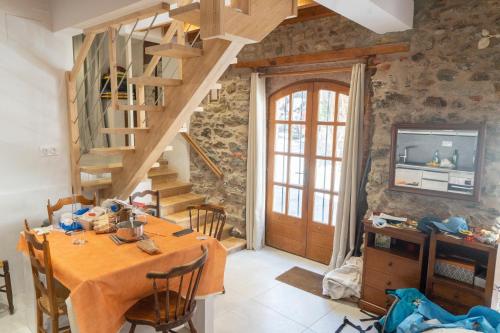une salle à manger avec une table et un escalier en bois dans l'établissement Maison 3ch 65m2 en bord de mer, à Banyuls-sur-Mer