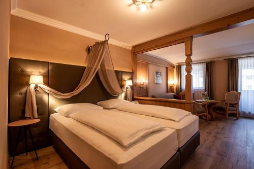sypialnia z dużym łóżkiem z baldachimem w obiekcie Hotel Hochfilzer w mieście Ellmau