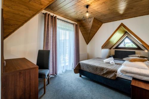 a bedroom with a bed and a desk and a window at Czeho House Domki Białka Tatrzańska in Białka Tatrzańska