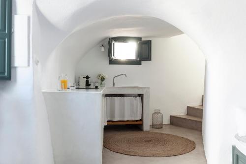a white bathroom with a sink and a rug at Spitia Santorini Villa Collection in Oia