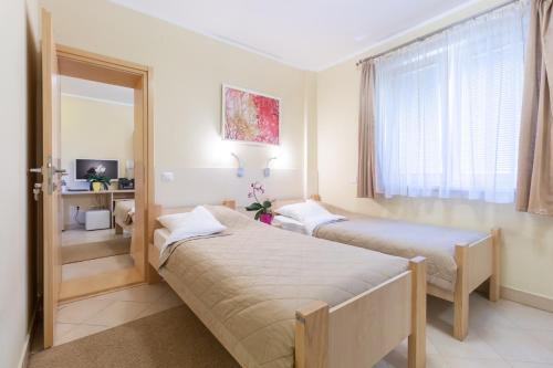 a hotel room with two beds and a window at Wing Club Hotel in Jagodina