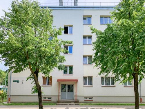um prédio de apartamentos com árvores em frente em ashlife_home em Liepāja