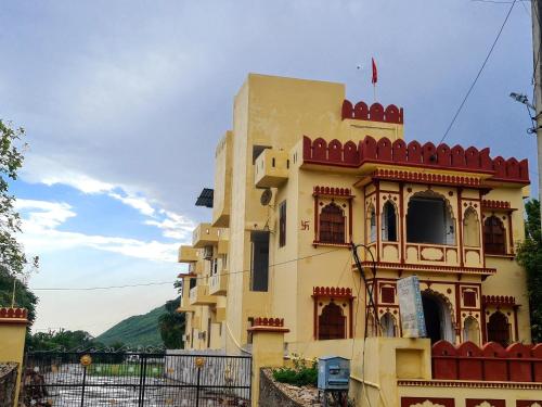 a yellow building with a red roof at Hotel Green Haveli - A Heritage and Hill View Hotel , Pushkar in Pushkar