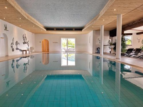 an indoor swimming pool with blue tiles on the floor at Berghoteltirol in Jungholz
