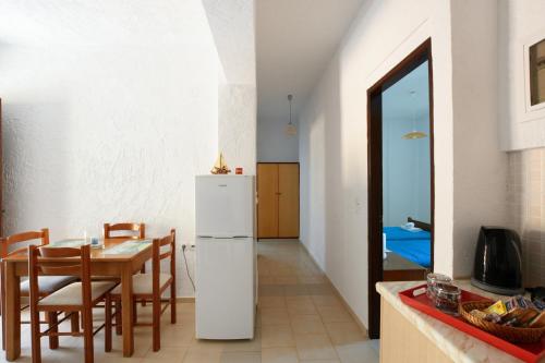 a kitchen and dining room with a table and a refrigerator at Galini Apartments in Achlia