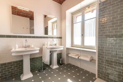 a bathroom with two sinks and a glass shower at Marchesi Incisa Winery Lodge in Rocchetta Tanaro
