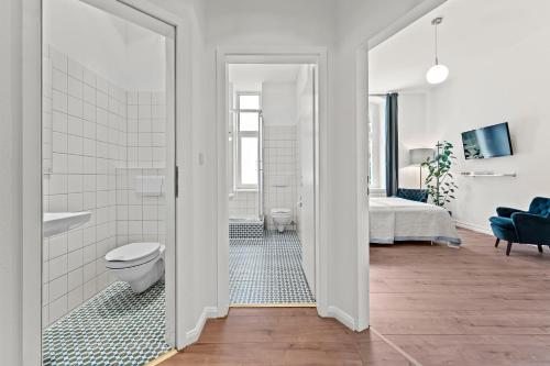 ベルリンにあるThe Weichsel - Group Flat in Central Berlin, Family-Friendly, 3BR, 2 bath rooms, 4- 6 Guestsの白いバスルーム(トイレ付)、ベッド1台が備わります。