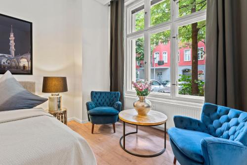ベルリンにあるThe Weichsel - Group Flat in Central Berlin, Family-Friendly, 3BR, 2 bath rooms, 4- 6 Guestsのベッドルーム1室(青い椅子2脚、ベッド1台、窓付)
