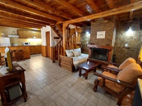 a living room with a stone fireplace in a house at Apart Manantial del Valle in San Martín de los Andes