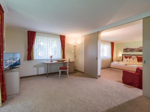 a hotel room with a desk and a bed at Hotel Glockenstuhl in Westendorf