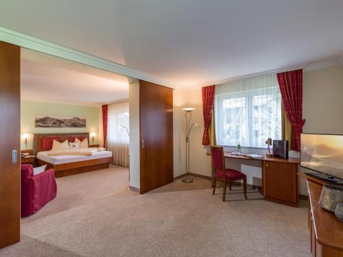 a hotel room with a bed and a desk at Hotel Glockenstuhl in Westendorf