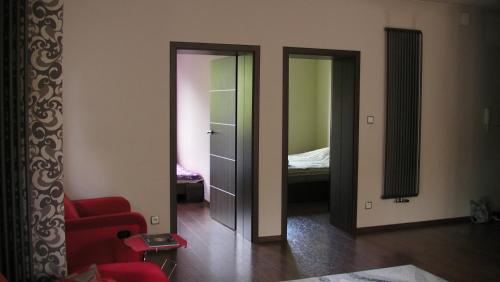 un soggiorno con sedia rossa e una camera da letto di Premium Apartment a Wisła