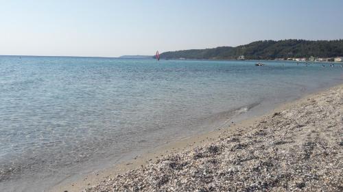 a beach with people swimming in the water at VILA ELENI FOURKA HALKIDIKI in Skala Fourkas