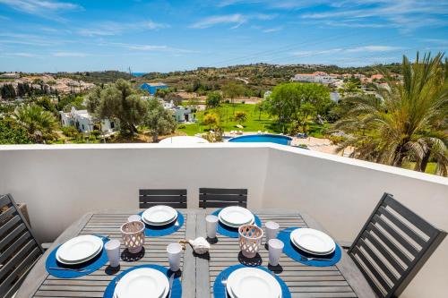 a table on a balcony with a view of the ocean at Albufeira Family Holidays with Pool View in Albufeira