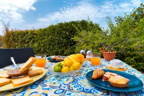een tafel met borden eten en fruit erop bij B&B Rosa Dei Venti in Parabita