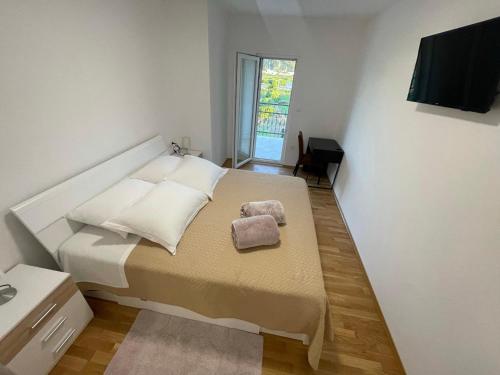 a bedroom with a bed with two towels on it at Apartman Mihaljević in Opuzen