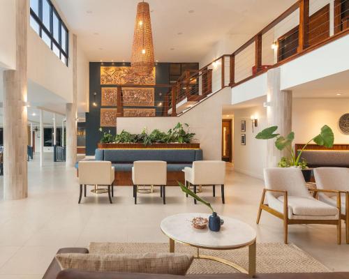 a lobby of a building with chairs and tables at Cara Hotels Trinidad in Claxton Bay