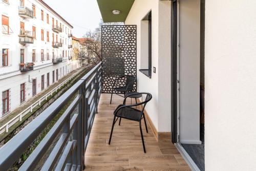 d'un balcon avec deux chaises et une balustrade. dans l'établissement Arany Apartman Miskolc, à Miskolc