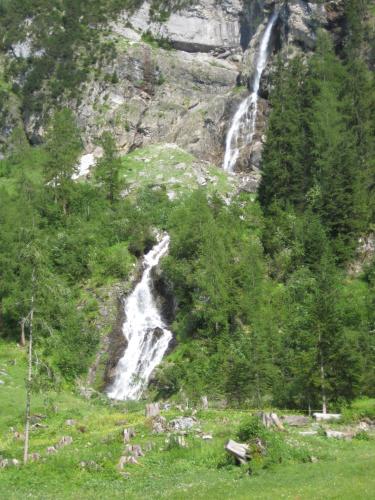 a waterfall on the side of a mountain at Schweiz ,Lenk Ferienwohnung,Kinderfreundl,Seniorenfreundlich in Lenk