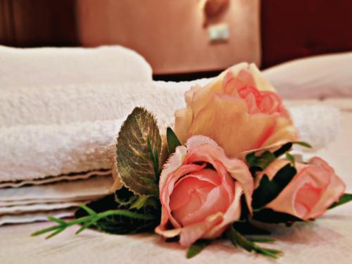 a bouquet of roses on a bed with towels at Vignali Residence in Diso