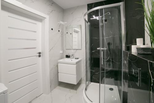een badkamer met een douche, een toilet en een wastafel bij Oxygen apartament nr 1 in Mielec