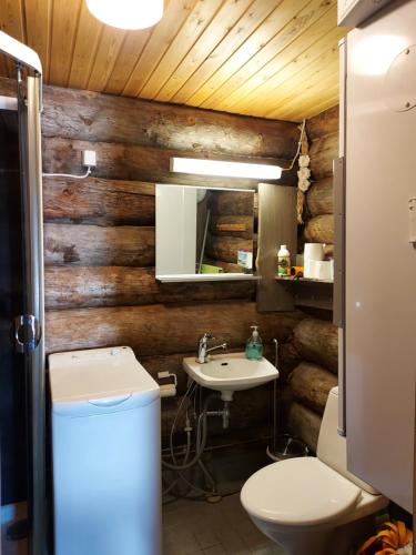 a bathroom with wooden walls and a toilet and a sink at Rukanpovi RP 7 - Studio in Ruka