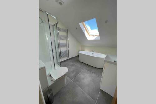 un bagno con vasca, WC e lavandino di The Loft Cottage a Glastry