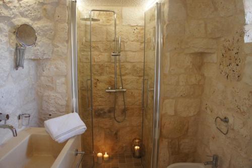 a bathroom with a shower with a sink and a toilet at Trulli La Pietraia in Ostuni