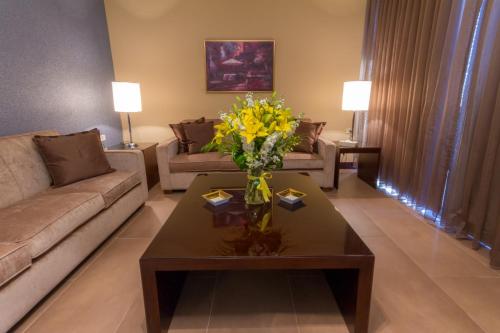 a living room with a couch and a table with yellow flowers at Nadine Hotel Suites in Amman