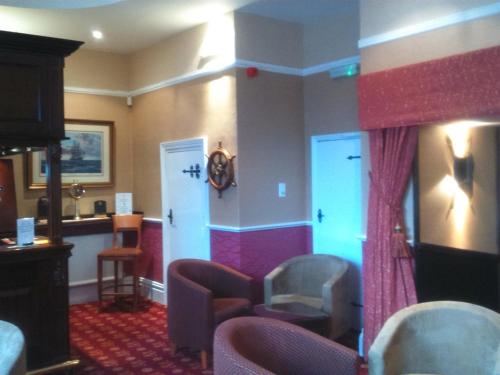 a waiting room with chairs and a tv at Hardwicke Hall Manor Hotel in Hartlepool