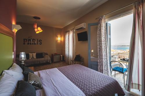 a hotel room with a bed and a balcony at Porto Bello Nafplio in Nafplio