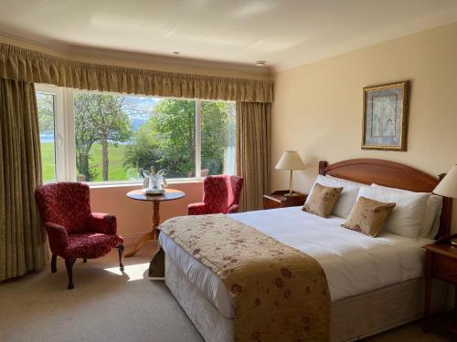 a hotel room with a bed and a large window at Loch Lein Country House in Killarney