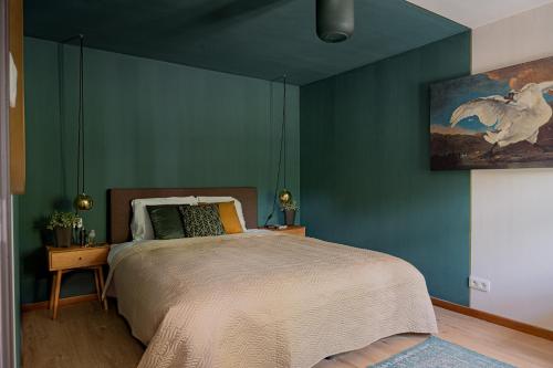 a bedroom with a bed with a blue wall at Cent Trente in Durbuy