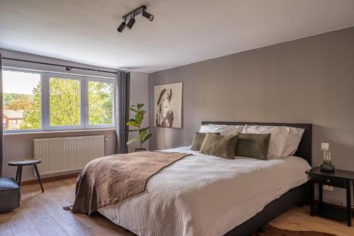 a bedroom with a large bed and a window at Cent Trente in Durbuy