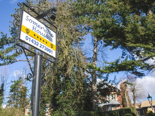 een straatbord op een paal voor een boom bij Somerville House in Hereford