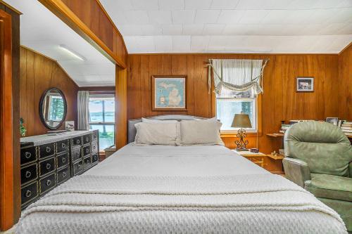 a bedroom with a large bed and a chair at Serenity in Honor