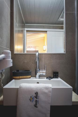 a bathroom with a sink and a mirror and a towel at Porto Bello Nafplio in Nafplio