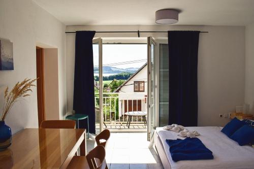 sypialnia z łóżkiem i stołem oraz balkonem w obiekcie Apartments Lakeview w Liptowskim Tarnowcu