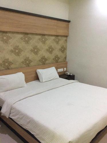 a bedroom with two beds with white sheets at HOTEL SRI VAARI RESIDENCY in Hosūr