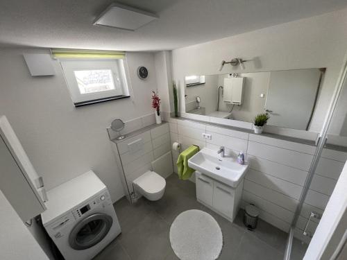 ein Badezimmer mit einem Waschbecken und einer Waschmaschine in der Unterkunft Casa Verde - Moos in Moos