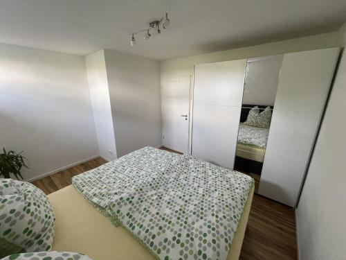 ein kleines Schlafzimmer mit einem Bett und einem Spiegel in der Unterkunft Casa Verde - Moos in Moos