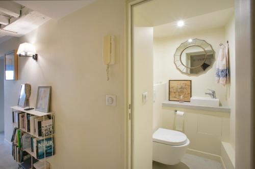 une salle de bain avec toilettes et miroir dans l'établissement TIMBAUD - CANAL St MARTIN, à Paris